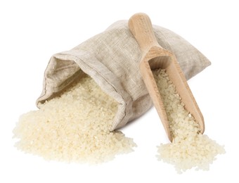 Photo of Raw rice, overturned burlap sack and wooden scoop isolated on white