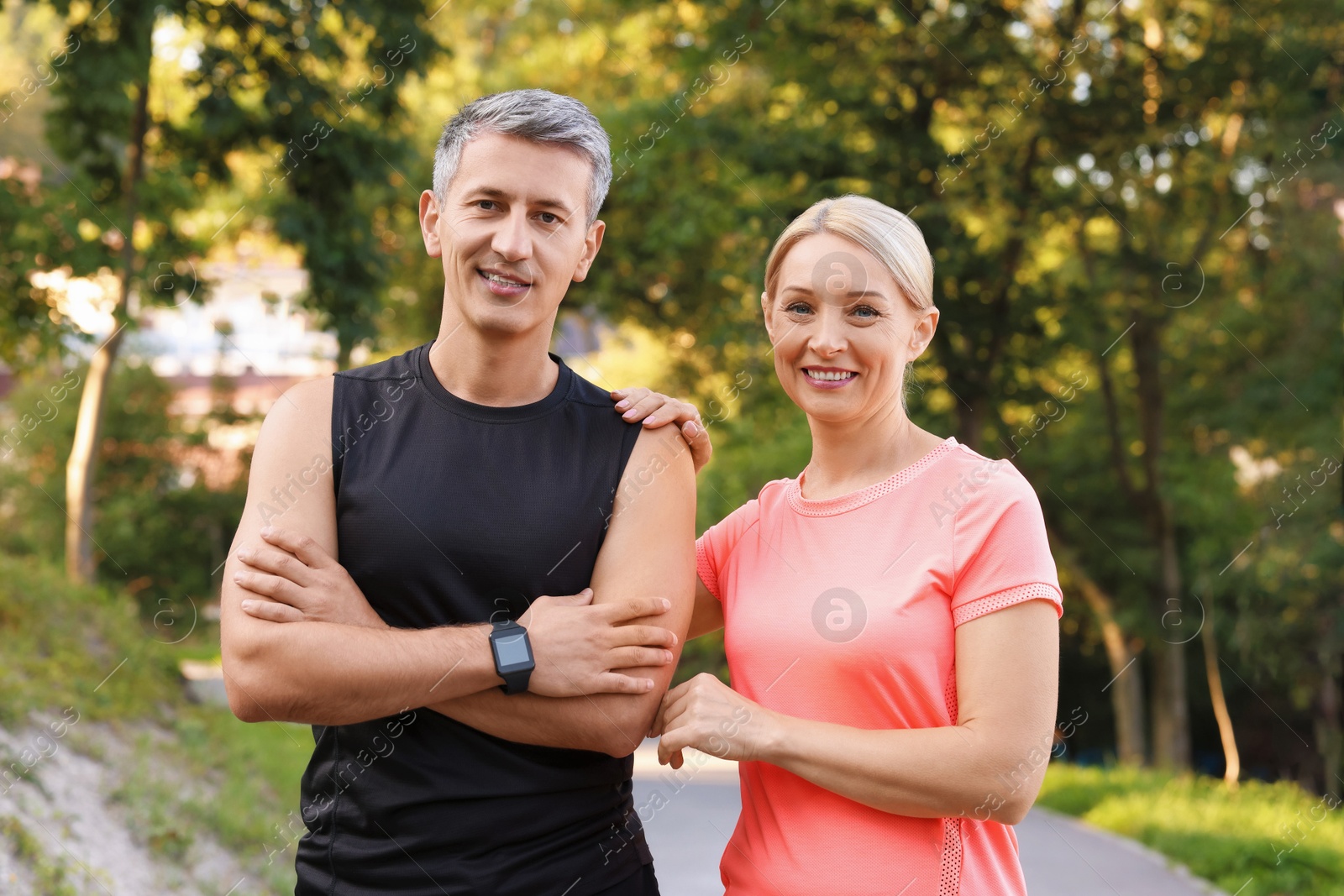 Photo of Portrait of happy couple in sportswears in park