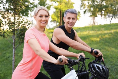 Happy couple riding bicycles in park. Healthy lifestyle