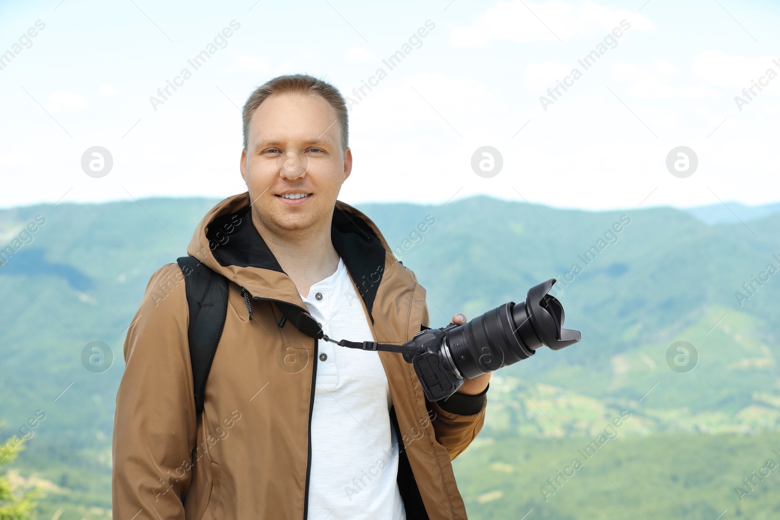 Photo of Photographer with backpack and camera in mountains