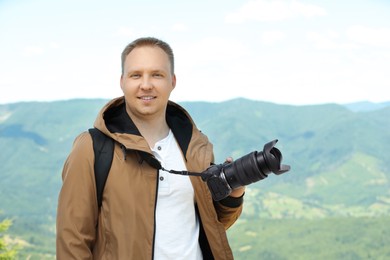 Photo of Photographer with backpack and camera in mountains