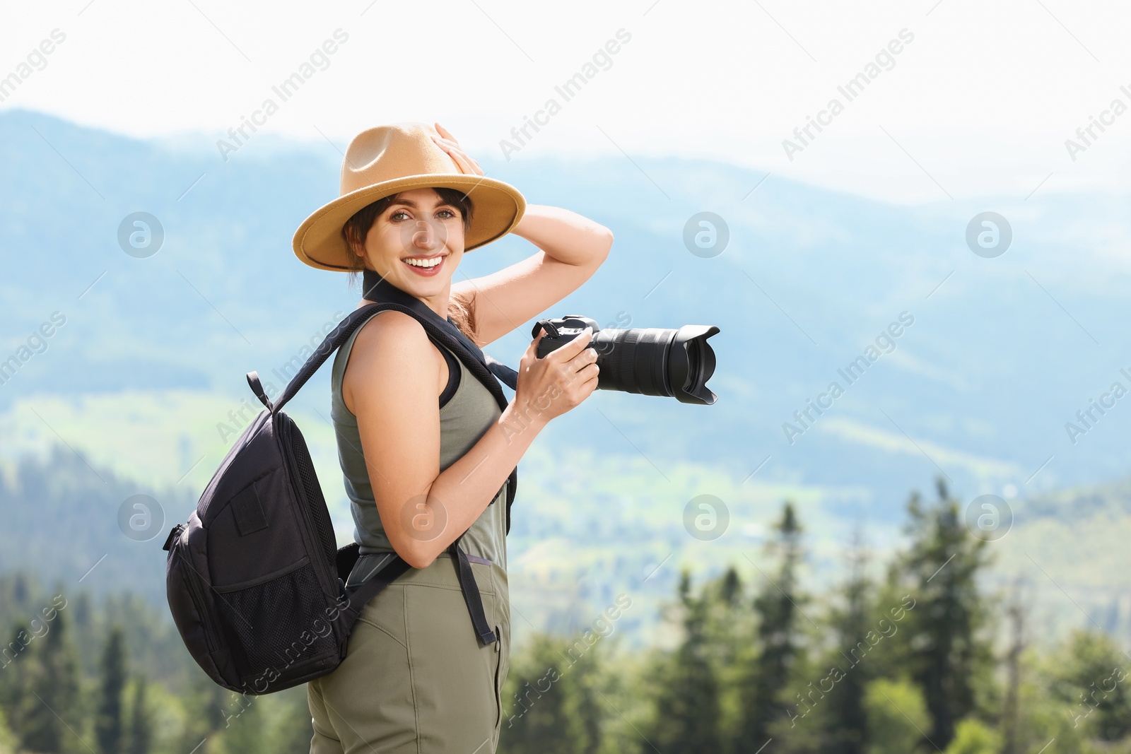 Photo of Photographer with backpack and camera in beautiful mountains