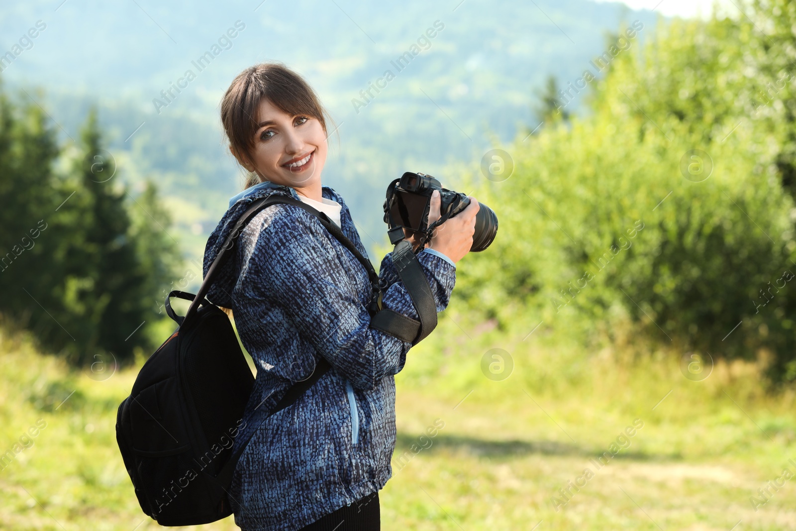 Photo of Photographer with backpack and camera in beautiful mountains