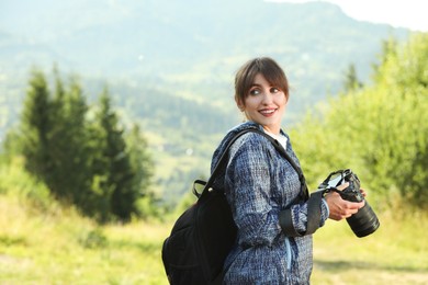 Photographer with backpack and camera in beautiful mountains. Space for text