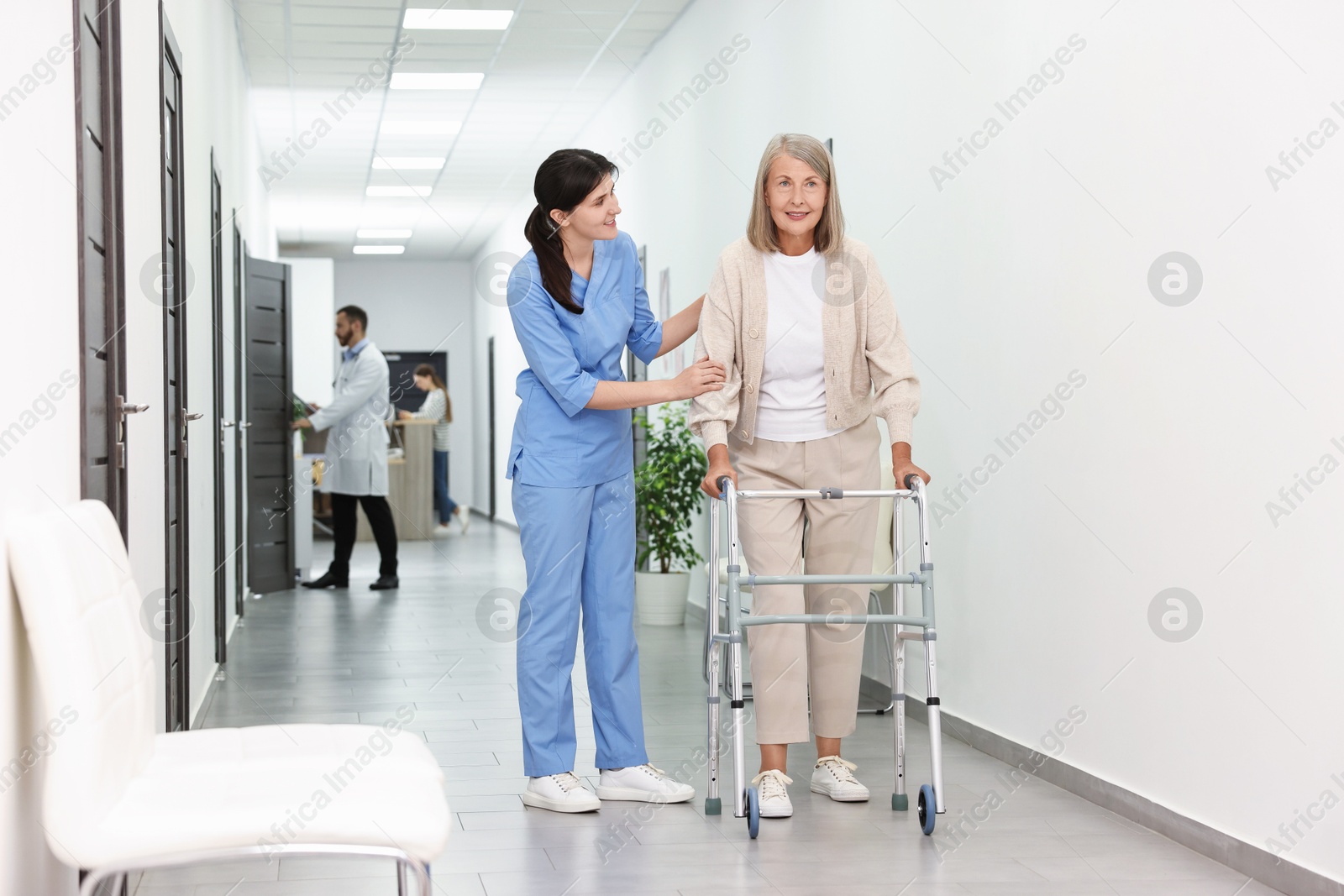 Photo of Nurse with senior woman in hospital hallway