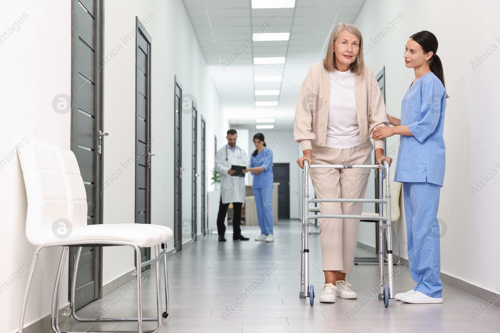 Photo of Nurse with senior woman in hospital hallway