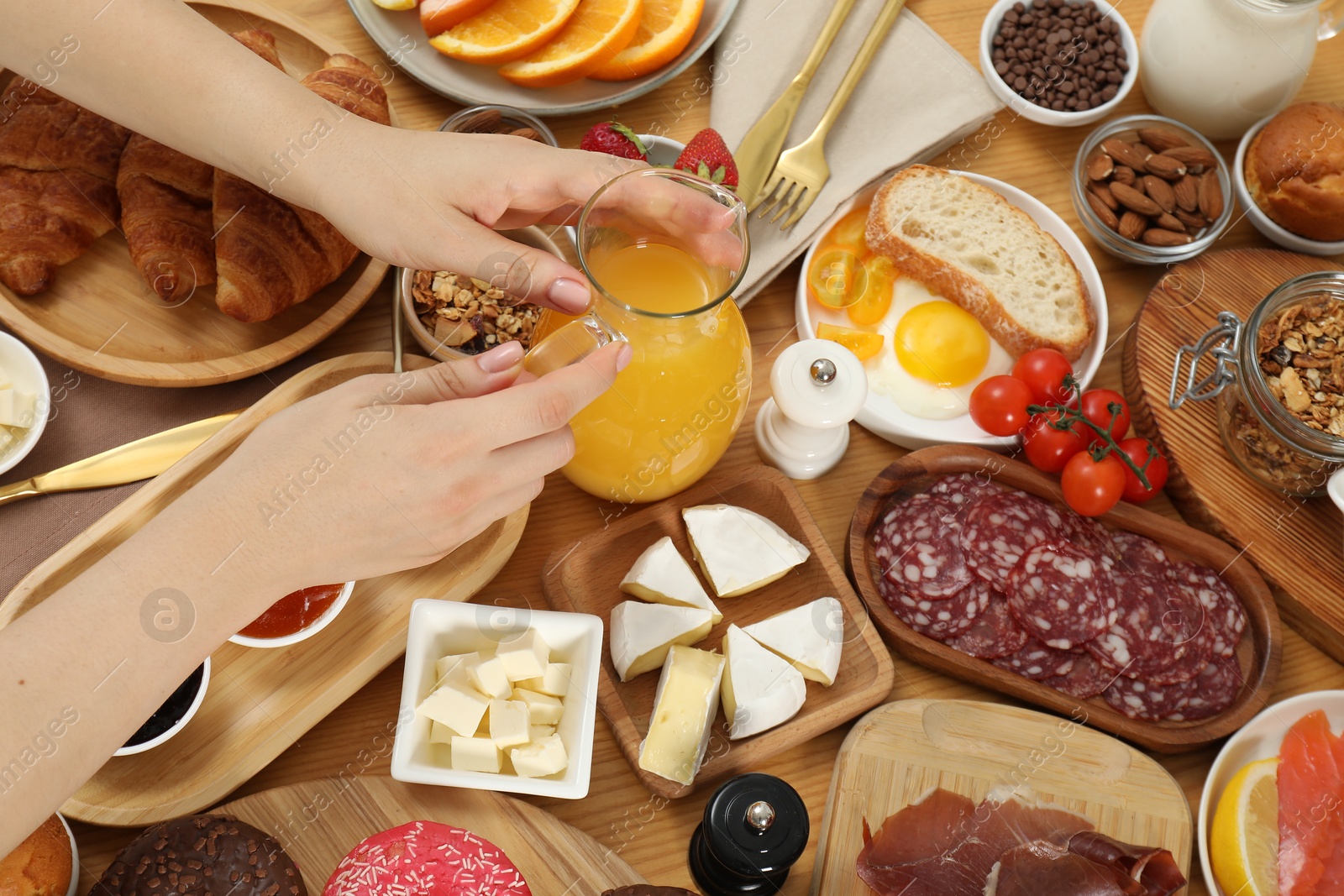 Photo of Woman eating different food during brunch at wooden table, top view