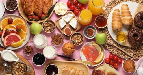 Photo of Different tasty food served for brunch on pink wooden table, flat lay