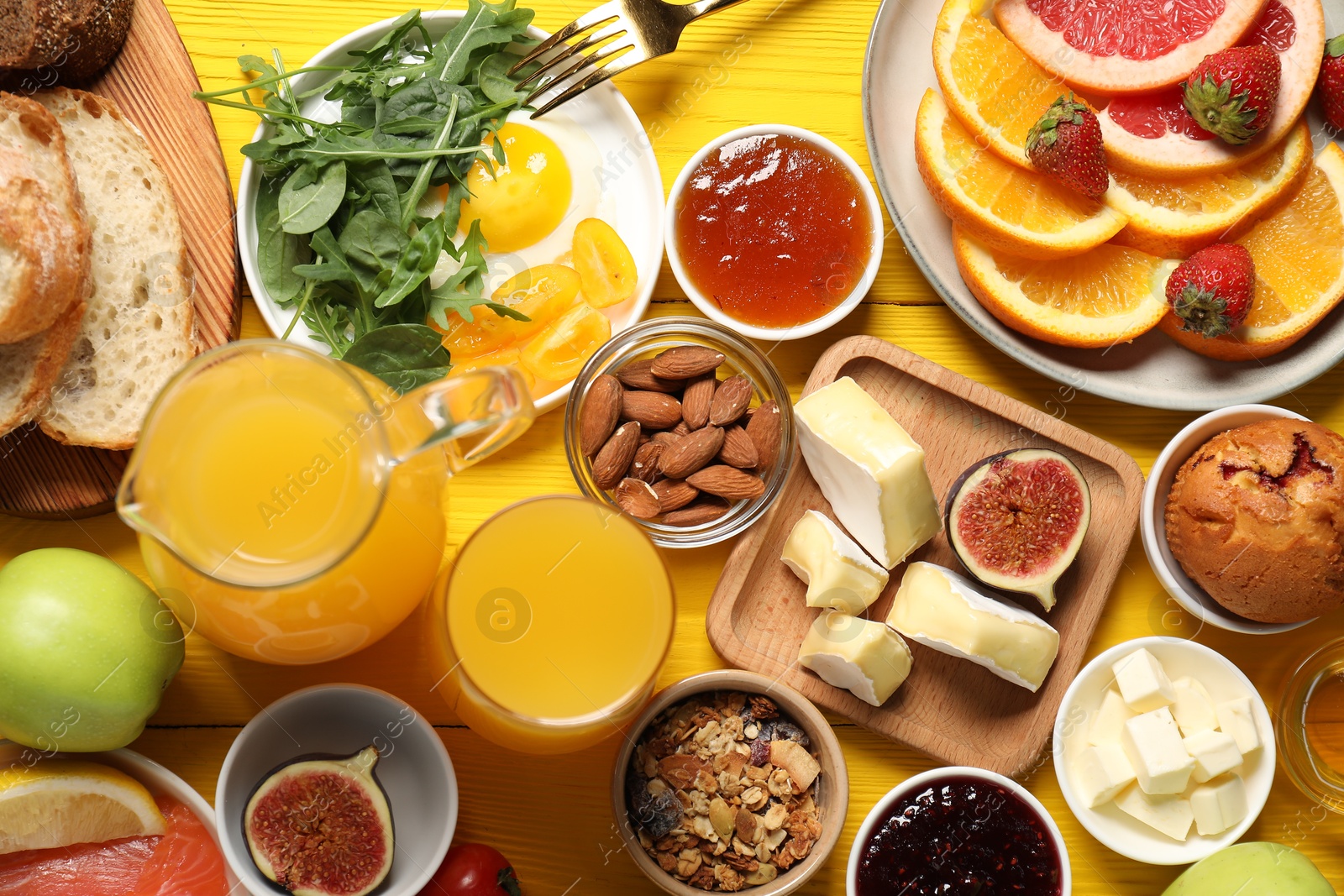 Photo of Different tasty food served for brunch on yellow wooden table, flat lay