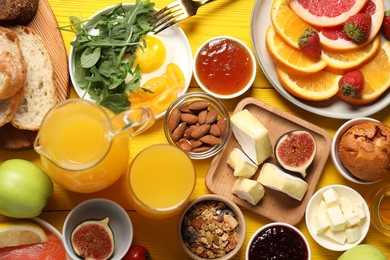 Photo of Different tasty food served for brunch on yellow wooden table, flat lay