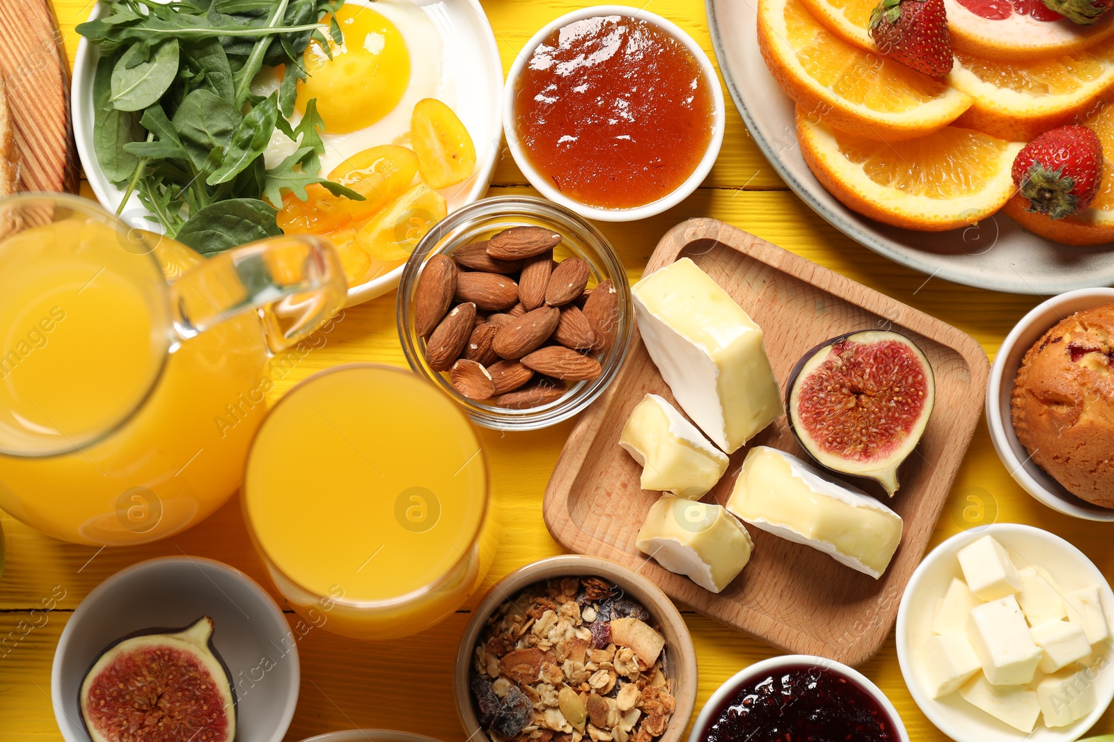 Photo of Different tasty food served for brunch on yellow wooden table, flat lay