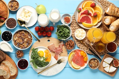 Photo of Different tasty food served for brunch on light blue wooden table, flat lay