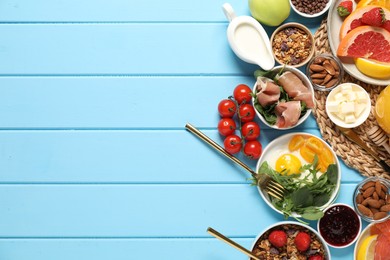 Photo of Different tasty food served for brunch on light blue wooden table, flat lay. Space for text