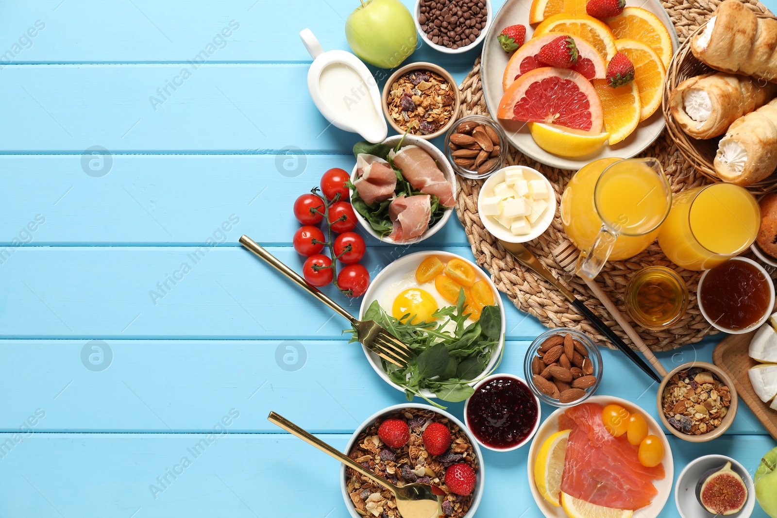 Photo of Different tasty food served for brunch on light blue wooden table, flat lay. Space for text