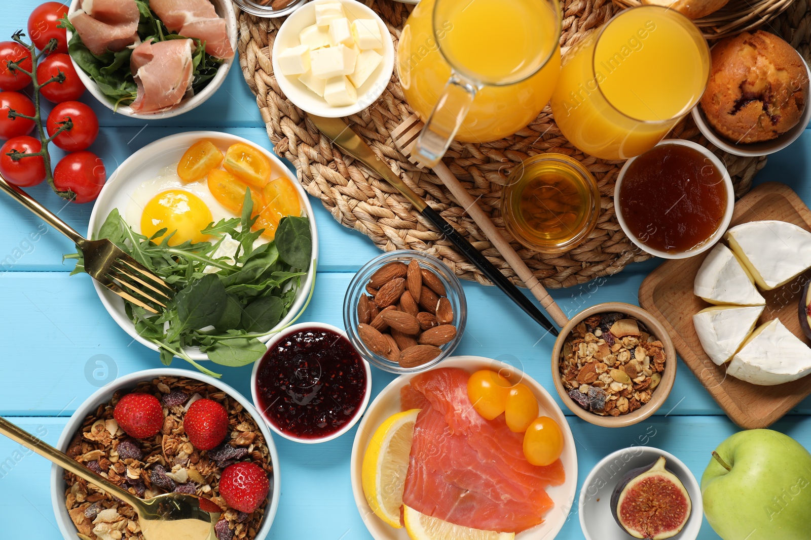 Photo of Different tasty food served for brunch on light blue wooden table, flat lay