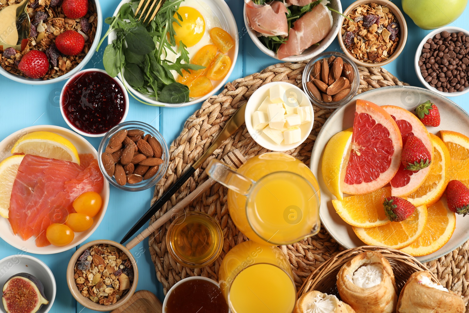 Photo of Different tasty food served for brunch on light blue wooden table, flat lay