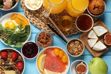 Photo of Different tasty food served for brunch on light blue wooden table, flat lay