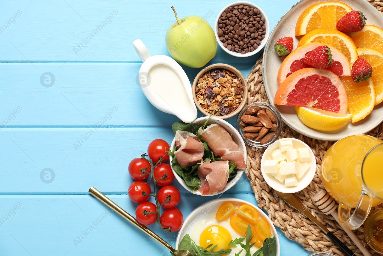 Photo of Different tasty food served for brunch on light blue wooden table, flat lay. Space for text