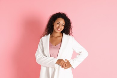 Beautiful woman in stylish jacket on pink background