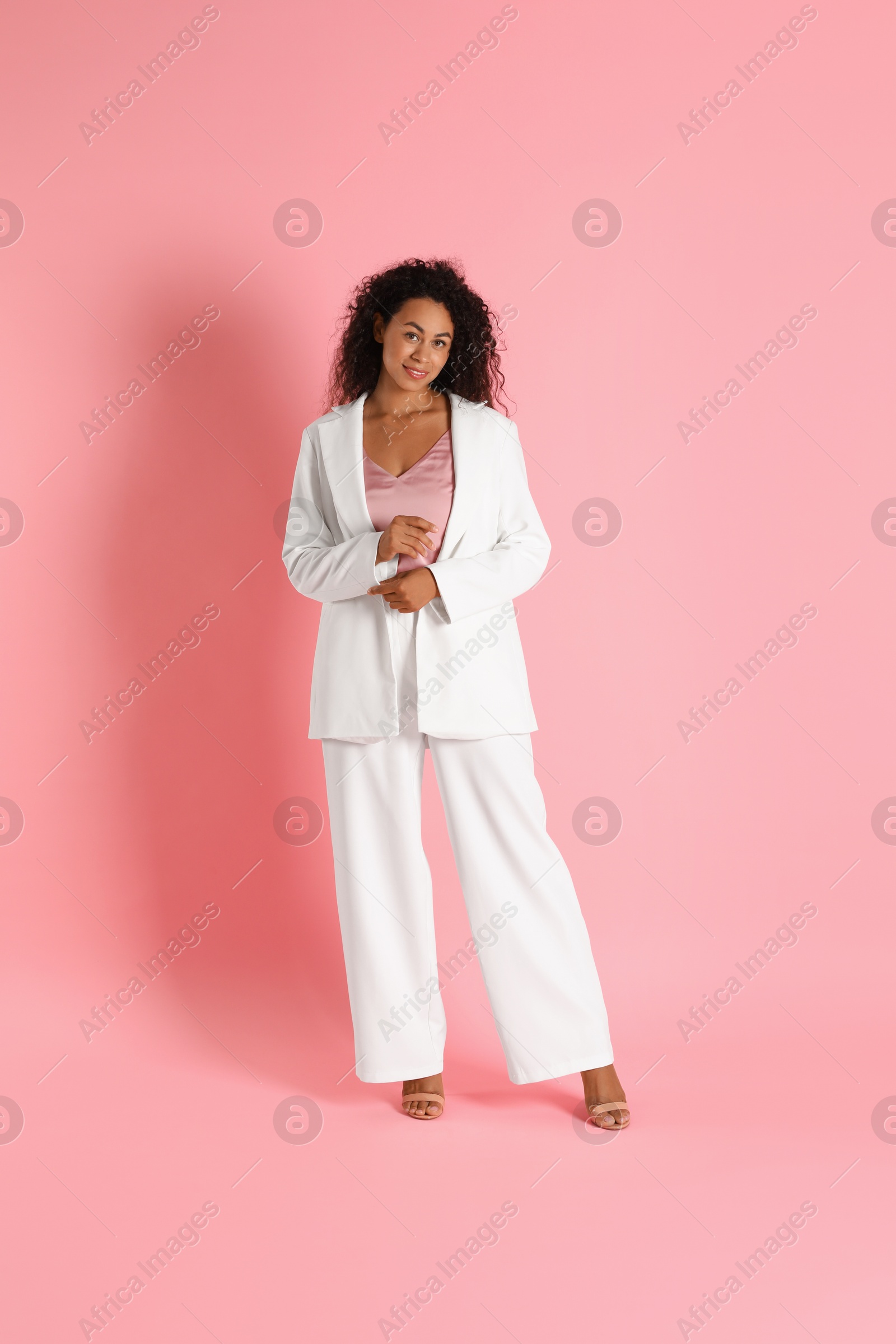 Photo of Beautiful woman in stylish suit on pink background