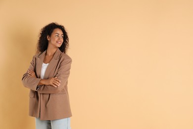 Beautiful woman in stylish jacket on beige background, space for text