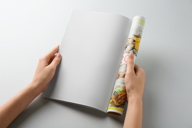 Woman reading magazine on grey background, closeup. Mockup for design