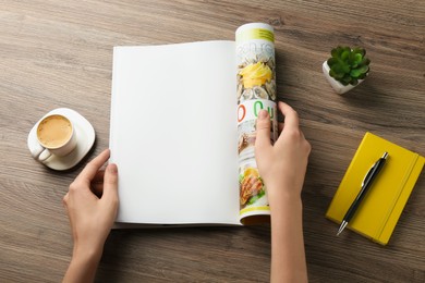 Woman reading magazine at wooden table, top view. Mockup for design