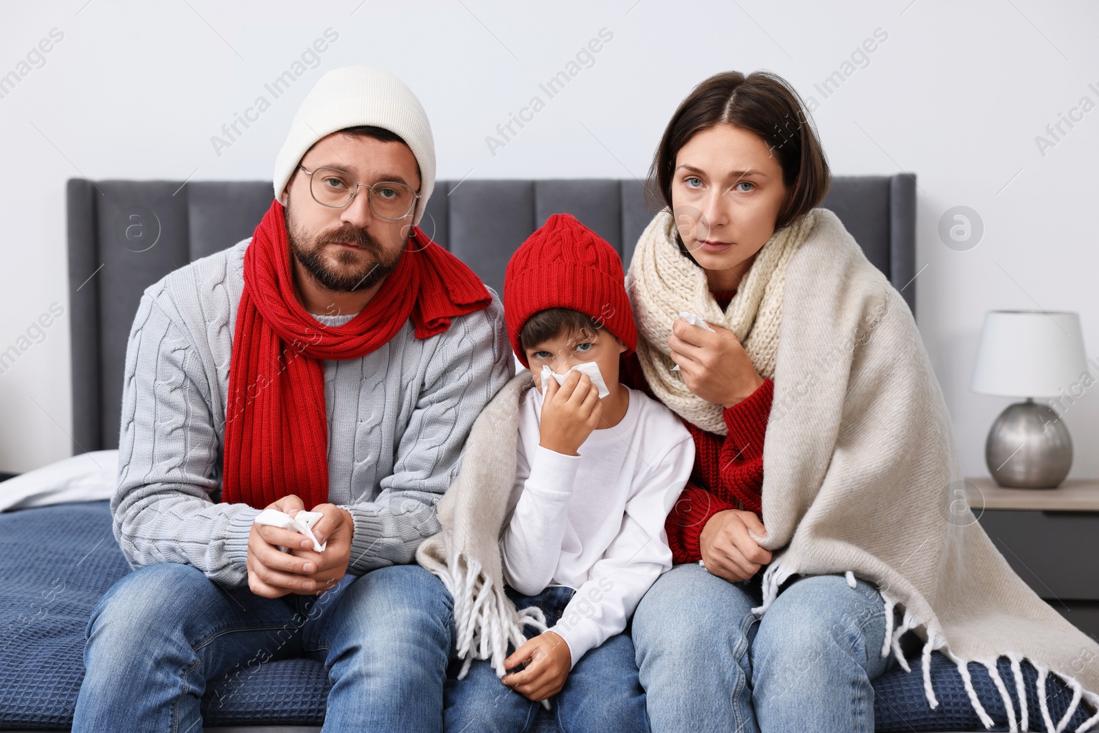 Photo of Cold symptom. Family suffering from fever on bed at home