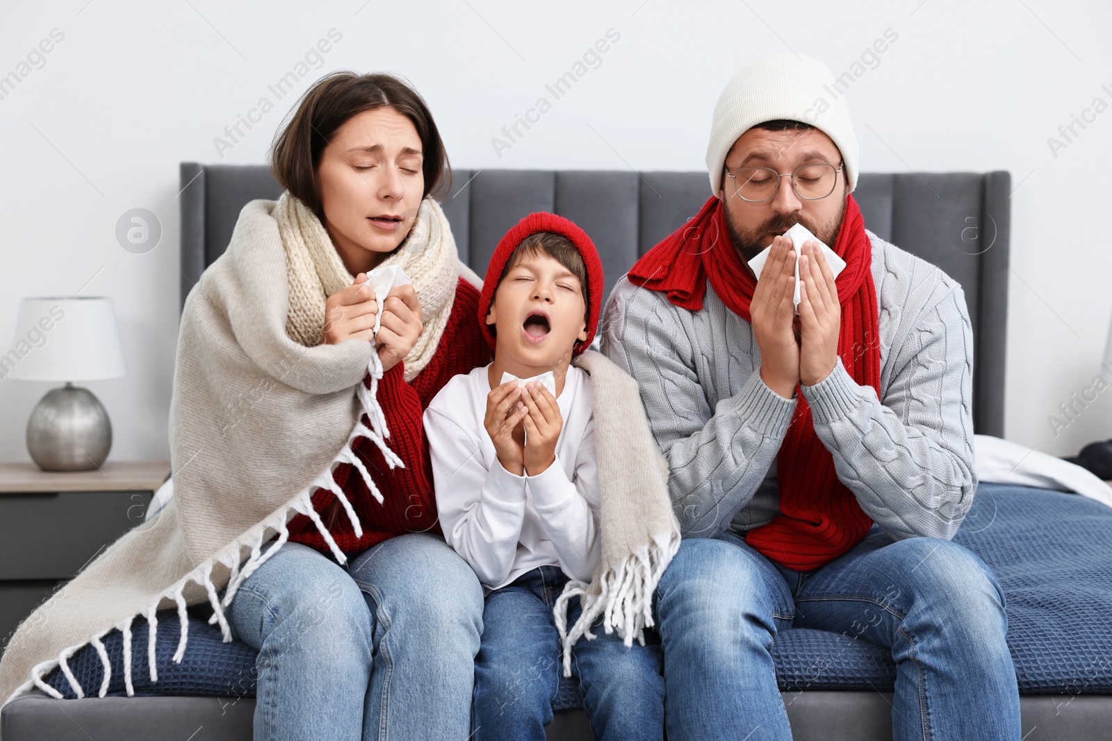 Photo of Cold symptom. Family suffering from fever on bed at home