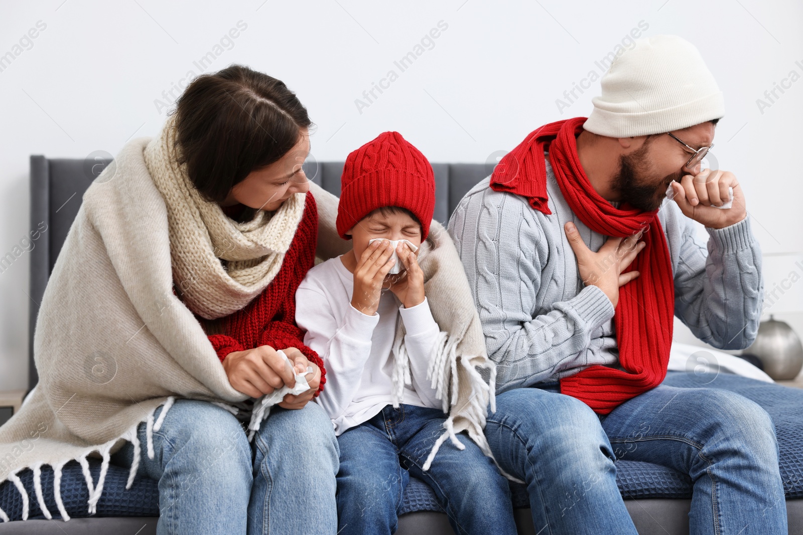 Photo of Cold symptom. Family suffering from fever on bed at home