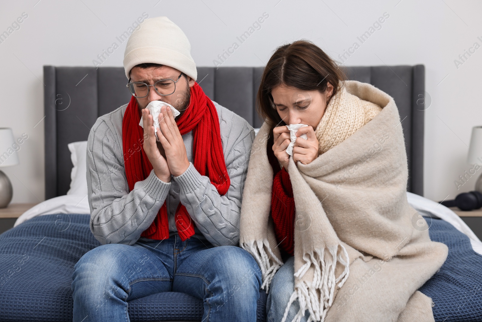 Photo of Cold symptom. Couple suffering from fever on bed at home