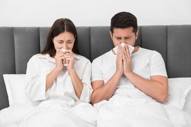 Photo of Cold symptom. Couple suffering from fever in bed at home