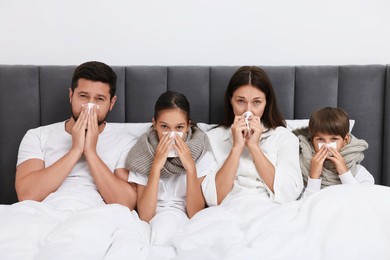 Cold symptom. Family suffering from fever in bed at home