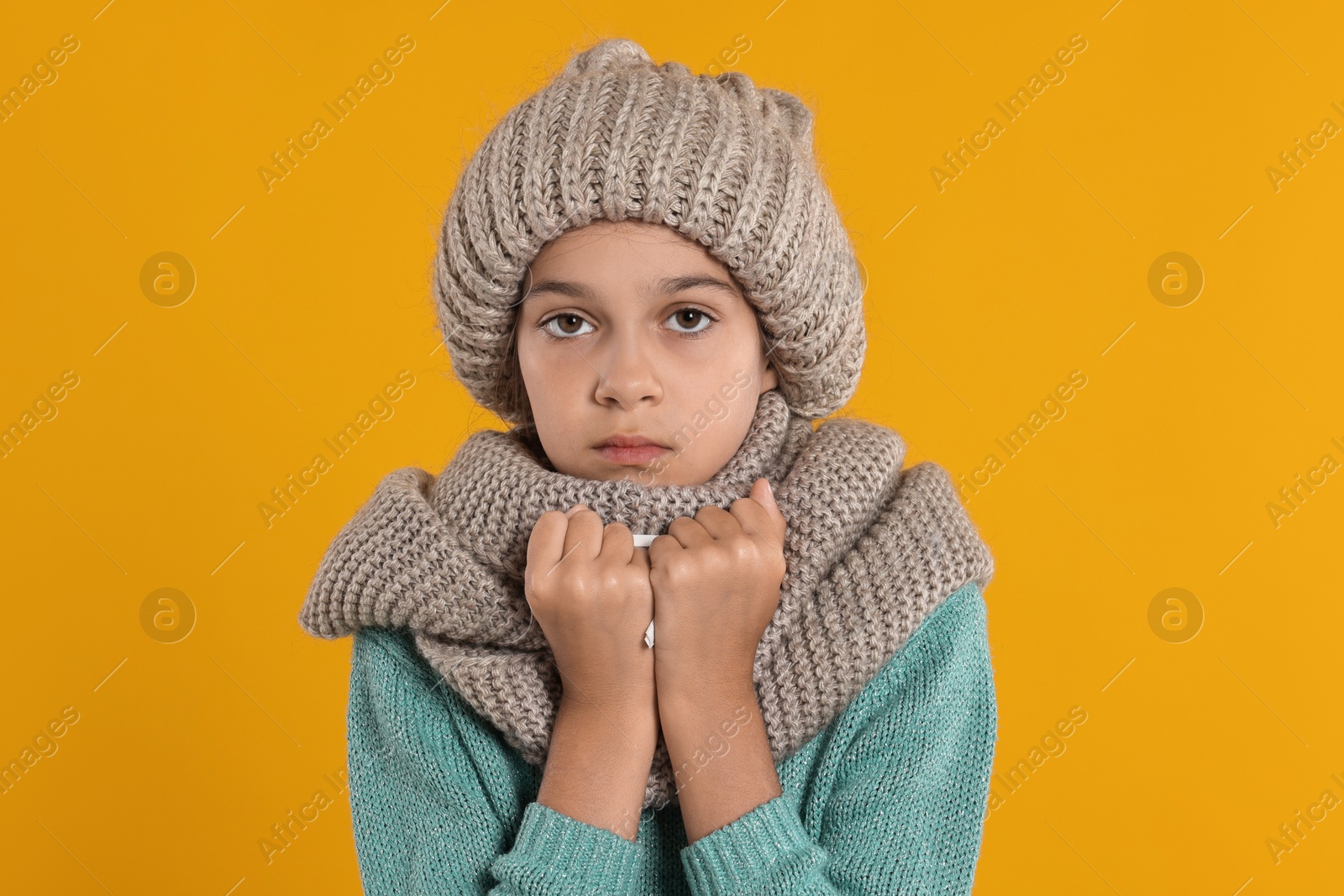 Photo of Cold symptom. Little girl suffering from fever on orange background