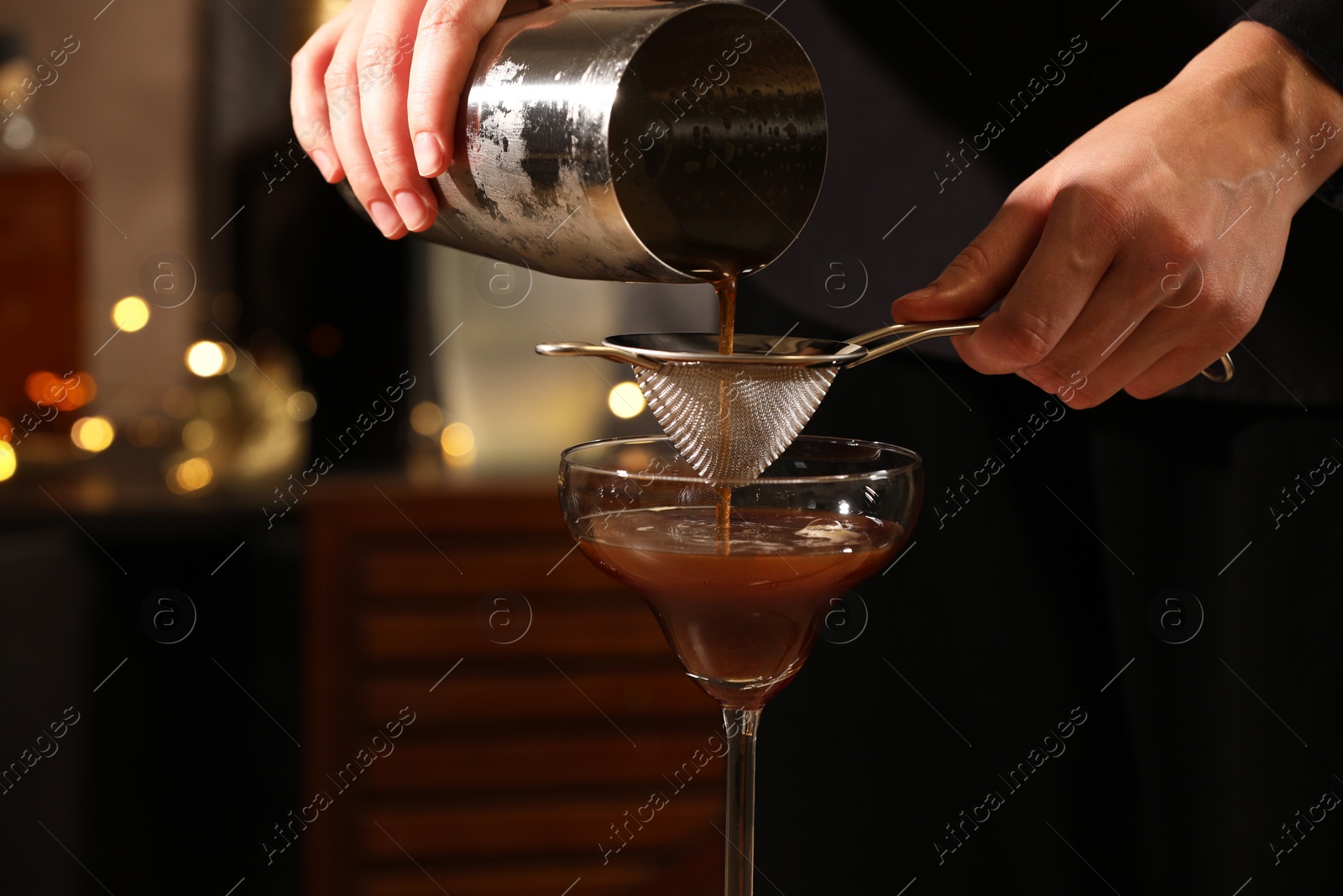 Photo of Bartender making delicious espresso martini in bar, closeup