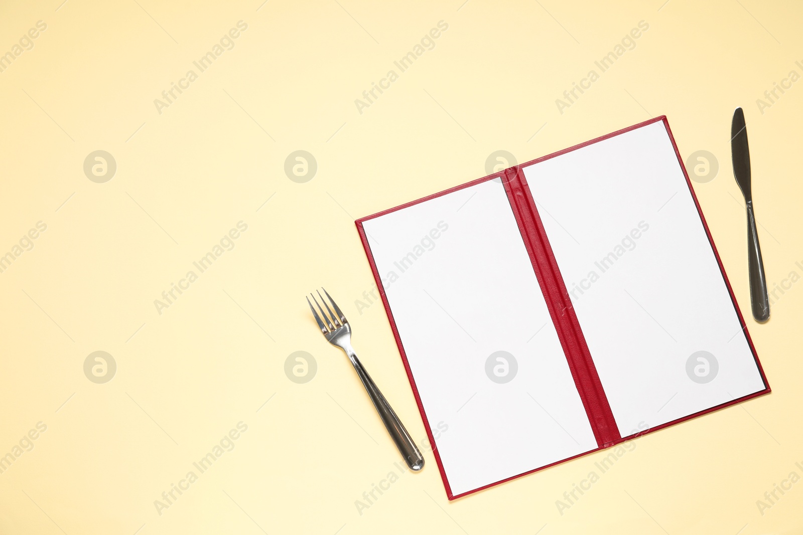 Photo of Hardcover notebook with blank sheets for menu design and cutlery on beige table, flat lay. Space for text