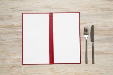 Photo of Hardcover notebook with blank sheets for menu design and cutlery on wooden table, flat lay