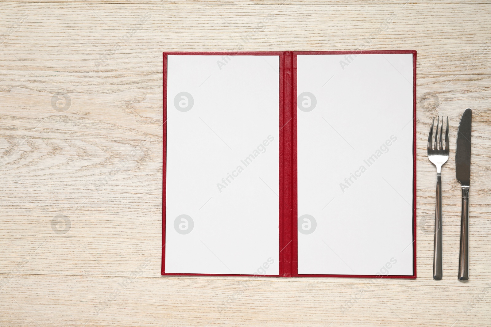 Photo of Hardcover notebook with blank sheets for menu design and cutlery on wooden table, flat lay