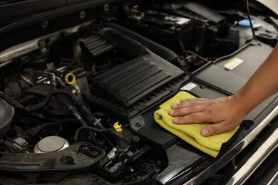 Photo of Man wiping auto engine with rag at car wash, closeup