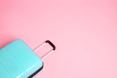 Photo of One new turquoise suitcase on pink background, above view. Space for text