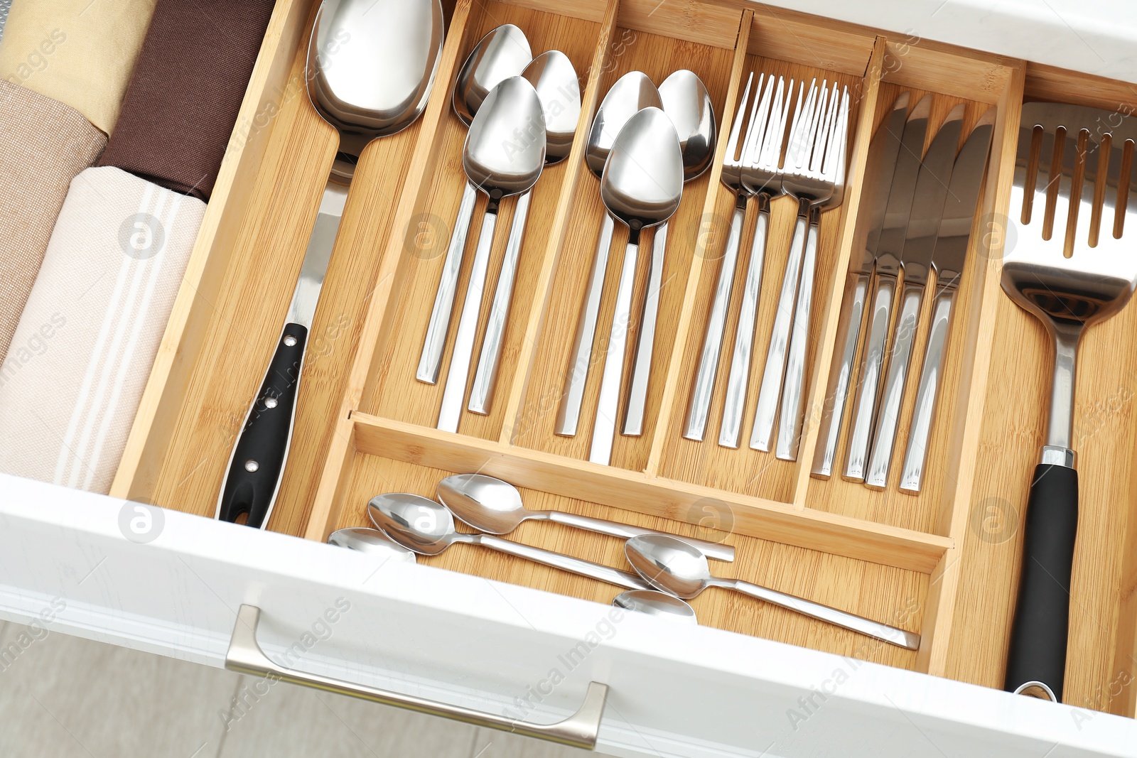 Photo of Box with cutlery in drawer, above view. Kitchen utensils storage