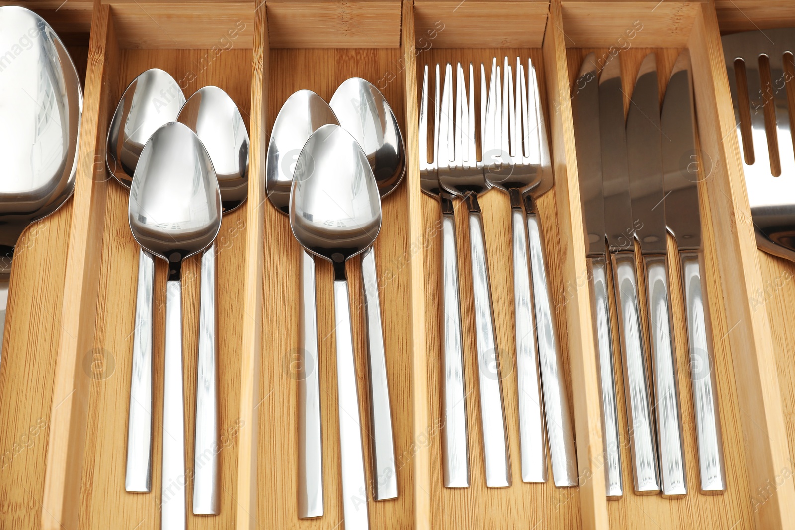 Photo of Box with cutlery in drawer, above view. Kitchen utensils storage