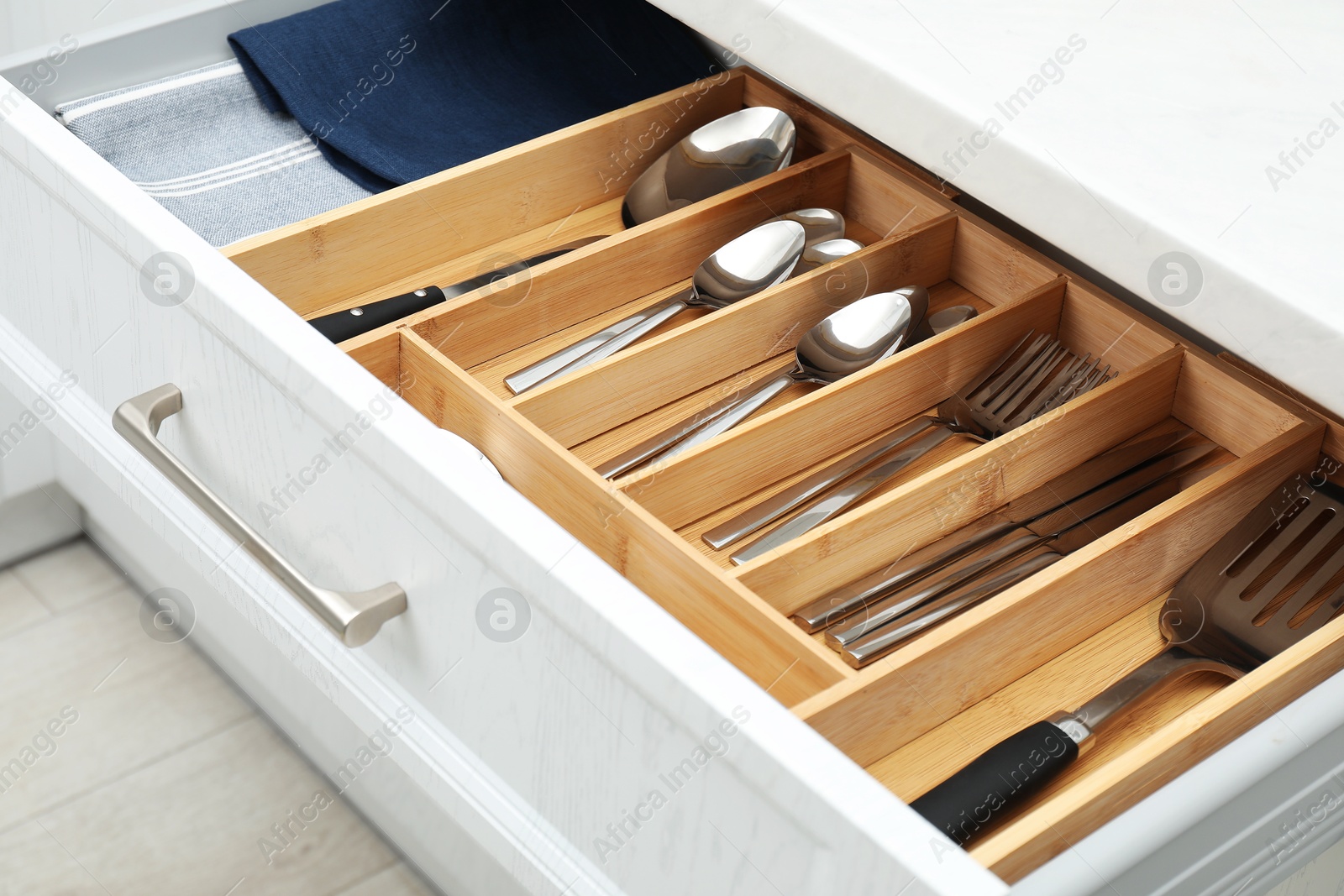 Photo of Box with cutlery in drawer, closeup. Kitchen utensils storage