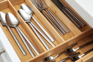 Photo of Box with cutlery in drawer, closeup. Kitchen utensils storage