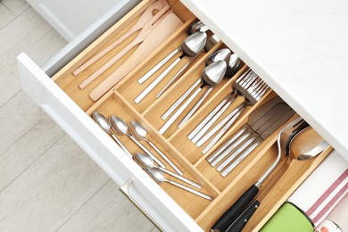 Photo of Box with cutlery in drawer, top view. Kitchen utensils storage