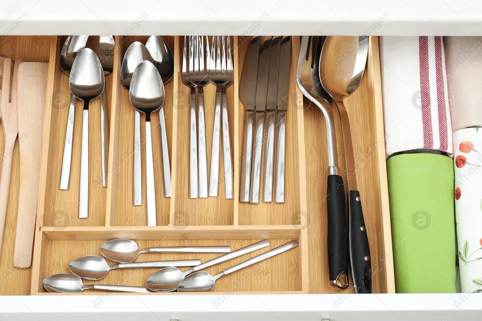 Photo of Box with cutlery in drawer, top view. Kitchen utensils storage