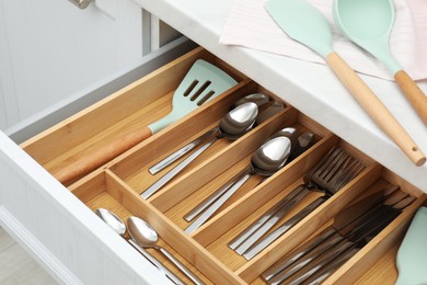 Photo of Box with cutlery in drawer, closeup. Kitchen utensils storage