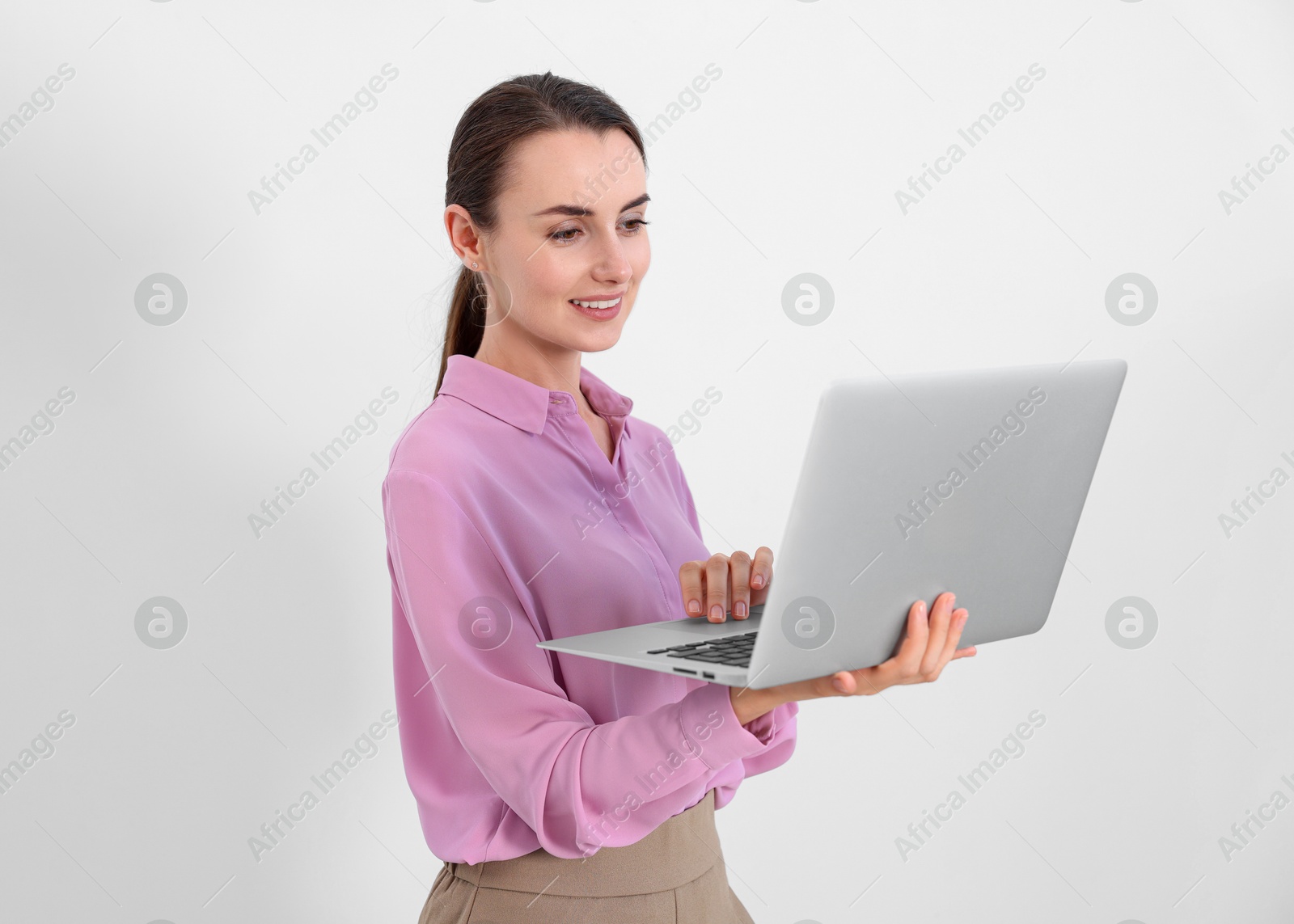 Photo of Portrait of smiling businesswoman working with laptop on white background