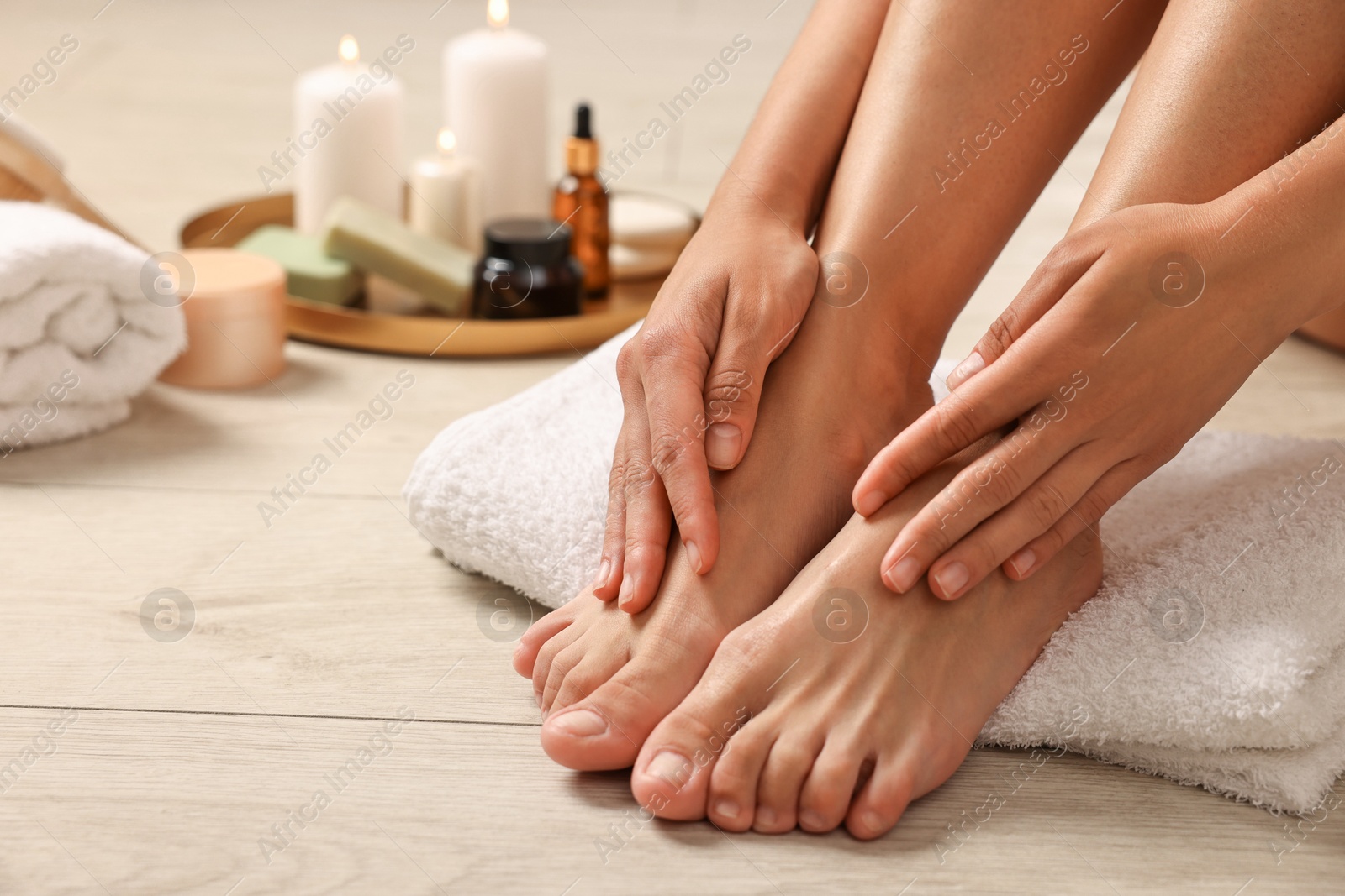 Photo of Woman touching her smooth feet on floor, closeup. Body care