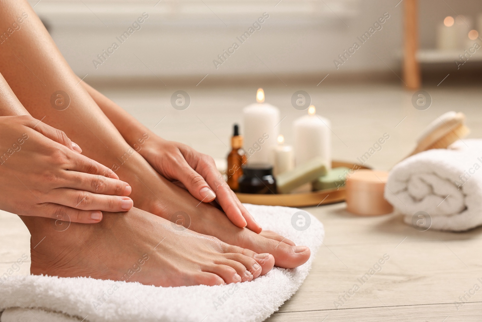 Photo of Woman touching her smooth feet on floor, closeup. Body care